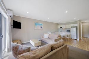 a living room with a couch and a table at Sea Foam Villas in Port Campbell