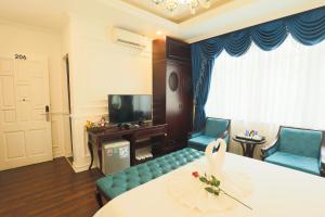 a living room with two chairs and a table and a tv at Hoàng Gia Xa La Boutique Hotel in Hanoi