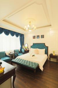 a bedroom with a bed and a couch and chairs at Hoàng Gia Xa La Boutique Hotel in Hanoi +42 photos