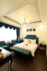 a bedroom with a large bed with a green couch at Hoàng Gia Xa La Boutique Hotel in Hanoi