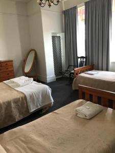 ein Hotelzimmer mit 2 Betten und einem Spiegel in der Unterkunft Lords Hotel Scottsdale in Scottsdale