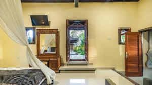 um quarto com uma cama e um espelho em Maruan Sari em Ubud