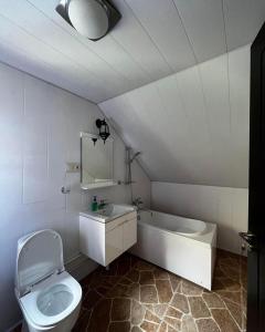 a bathroom with a toilet and a tub and a sink at Juta Guest House in Jut'a