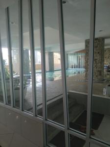 una finestra in vetro con vista sulla piscina. di AL Fateh Apartment Wakaf Che Yeh a Wakaf Che Yeh