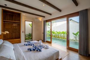 a bedroom with a bed and a view of a pool at Atania Villa's Bingin in Uluwatu