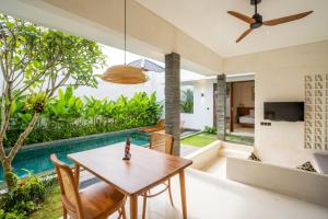 a dining room with a table and a swimming pool at Atania Villa's Bingin in Uluwatu