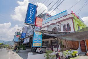 a group of signs on the side of a street at RedDoorz Syariah near Danau Lut Tawar Takengon in Takengon