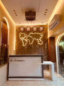 El mansour hotel apartmen 81 في المنصورة: لوبي وحائط عليه ساعات