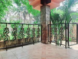 Un balcón con una valla de hierro forjado y árboles en Strawberry Swing Homestay, en Guwahati