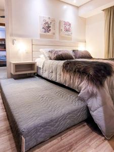Un dormitorio con una cama grande con una alfombra grande en Morada das Hortênsias lindo e acolhedor no Centro, en Gramado