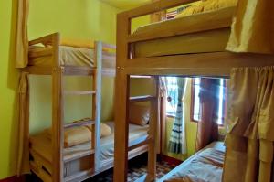 ルテンにあるRuteng Hostelの二段ベッド2台付きの部屋とベッド1台付きの部屋があります。
