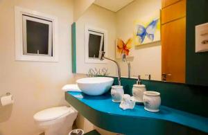 un baño con lavabo e inodoro en Flores da Montanha 301B, en Gramado 30 fotos más