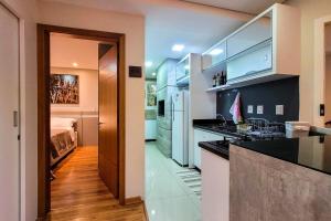 una cocina con fregadero y encimera en Flores da Montanha 301B, en Gramado