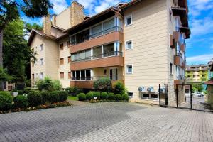 un gran edificio con una entrada delante de él en Flores da Montanha 301B, en Gramado