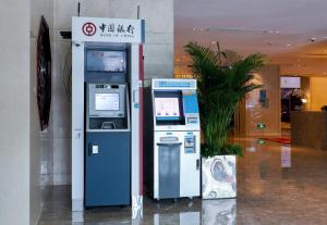 una máquina atm en un edificio con una señal en Crowne Plaza Beijing Sun Palace, an IHG Hotel, en Beijing