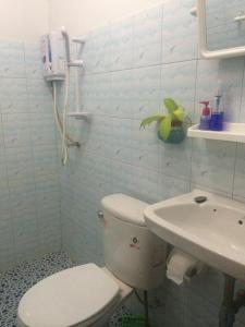 a bathroom with a white toilet and a sink at Huen Him Bung in Chiang Rai