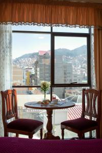 a table and two chairs in front of a large window at Hotel Diamante Azul in La Paz