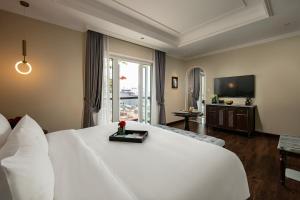 a hotel room with a large white bed and a television at La Mejor Hotel & Sky Bar in Hanoi