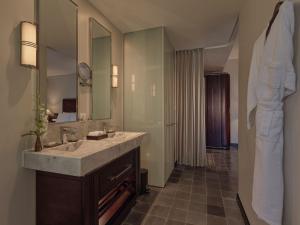 a bathroom with a sink and a large mirror at Azerai La Residence, Hue in Hue