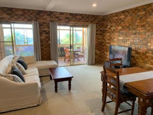 een woonkamer met een bakstenen muur bij Ocean View in Port Macquarie