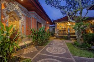 a walkway in front of a house with a tree at KUDESA Homestay by Pramana Villas in Ubud