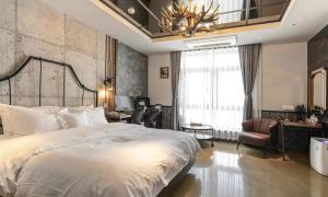 大邱的住宿－大邱東城區二月酒店，一间卧室配有一张大床和一个吊灯。