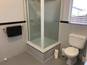 een badkamer met een douche en een toilet bij Ocean View in Port Macquarie