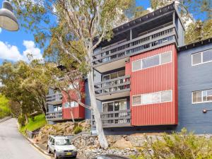 un immeuble d'appartements avec extérieur rouge et gris dans l'établissement 2B Bobuck, à Thredbo