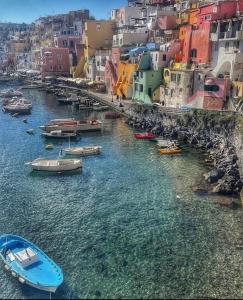 a group of boats in a river with buildings at La casa del postino in Procida
