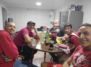 Un gruppo di uomini seduti intorno a un tavolo con bevande di Felicata a Sarmiento