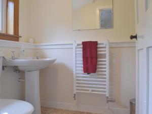 a bathroom with a sink and a red towel at Castleview West in Lochearnhead