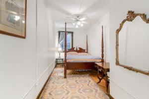 a bedroom with a bed and a mirror at Pasters Apartment in Deconsecrated Church in New Orleans