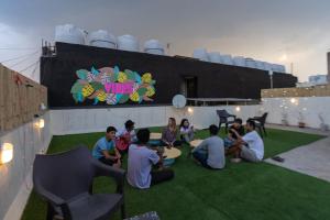 eine Gruppe von Menschen, die um einen Tisch auf einem Dach sitzen in der Unterkunft AmigosIndia in Neu-Delhi
