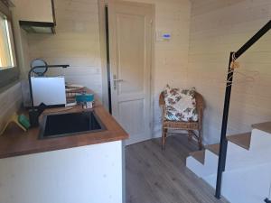 uma cozinha com um lavatório e uma cadeira num quarto em Tiny House Waldschmied 1 