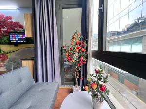 a living room with a couch and a window with flowers at Phoenix Flower Room R202-Central Saigon-near Ben Thanh in Ho Chi Minh City