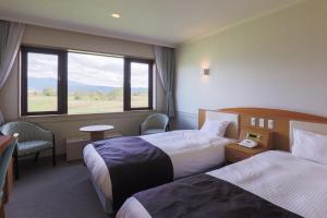 中富良野町的住宿－富良野拉漁村酒店，酒店客房设有两张床和窗户。