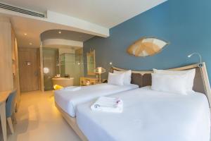 two beds in a hotel room with blue walls at Beyond Patong in Patong Beach