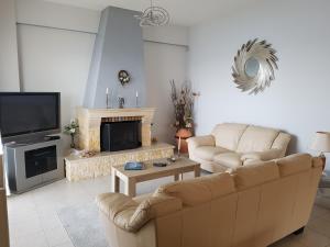 Sala de estar con 2 sofás y TV en ENASTRON HOME WITH SEA VIEW, en Palaiokastro