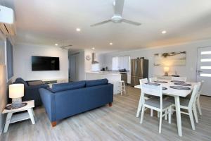 a living room with a blue couch and a table at Tanner St Retreat in Bargara