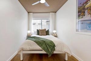 a bedroom with a bed with a ceiling fan at PALMA - Couples Beach Shack! in Gold Coast