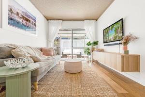 a living room with a couch and a table at PALMA - Couples Beach Shack! in Gold Coast