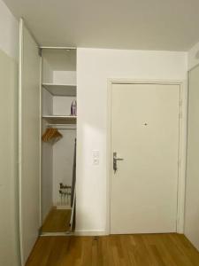 an empty room with a white door and a closet at Studio Cosy à 10 min de Paris in Deuil-la-Barre