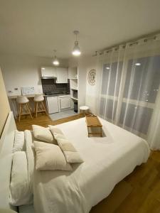 1 cama blanca grande en una habitación con cocina en Studio Cosy à 10 min de Paris, en Deuil-la-Barre