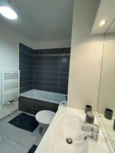 a bathroom with a sink and a toilet and a tub at Studio Cosy à 10 min de Paris in Deuil-la-Barre