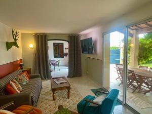 een woonkamer met een bank en een tafel bij Villa spa, sauna et piscine couverte proche rivière Aveyron in Albias