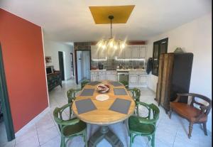 Villa spa, sauna et piscine couverte proche rivière Aveyron في Albias: مطبخ وغرفة طعام مع طاولة وكراسي