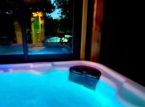 d'une baignoire avec deux seaux et une fenêtre. dans l'établissement Villa spa, sauna et piscine couverte proche rivière Aveyron, à Albias