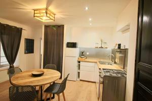 Appartement centre Brioude في بريود: مطبخ مع طاولة خشبية وطاولة وكراسي