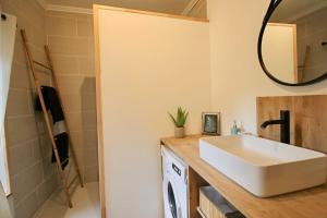 Appartement centre Brioude في بريود: حمام مع حوض أبيض ومرآة
