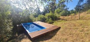 a swimming pool on a wooden deck in a field at Peña de Horeb in Villa Serrana
